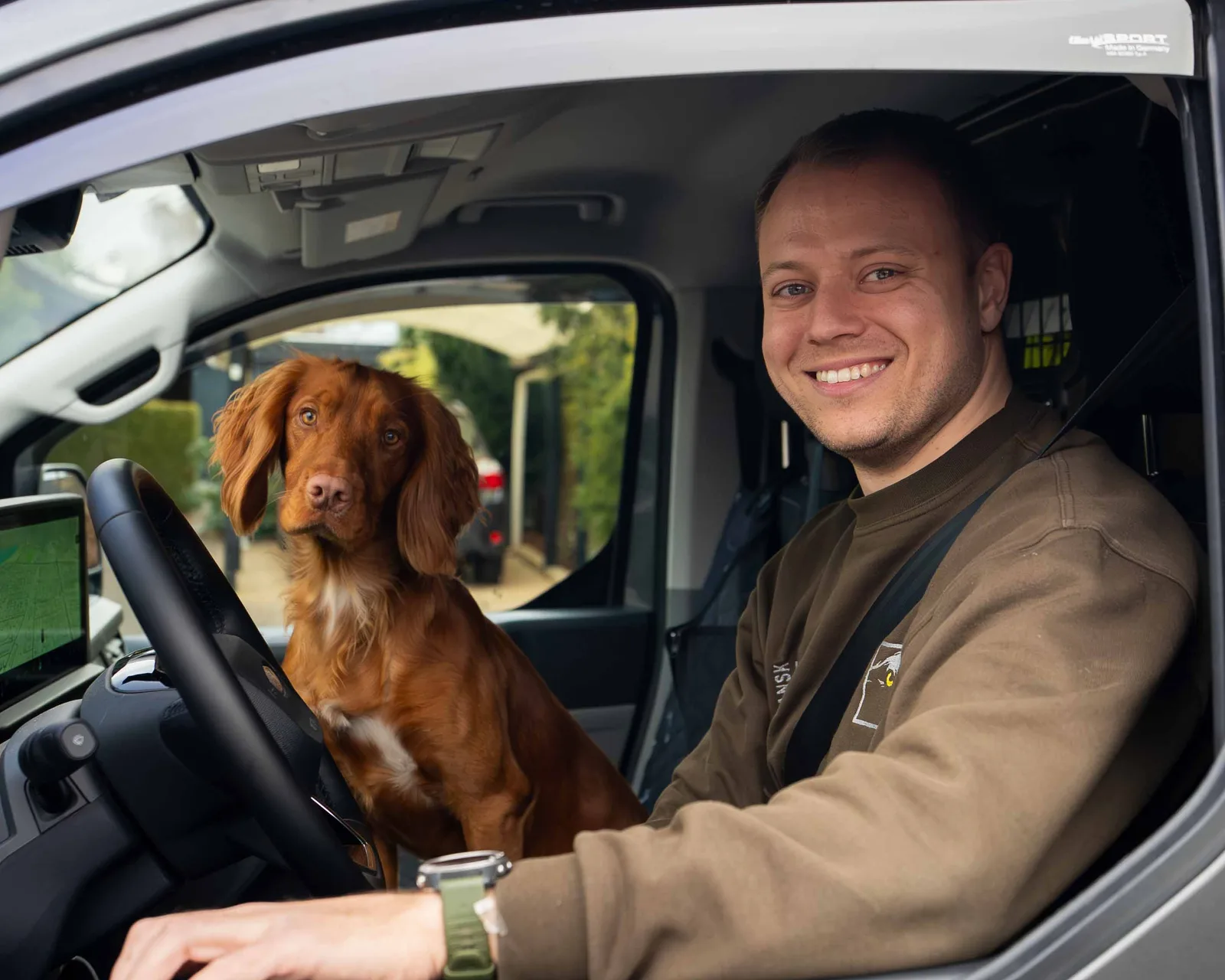 Frederik fra Dansk Låse & Alarm i firmabilen med hunden